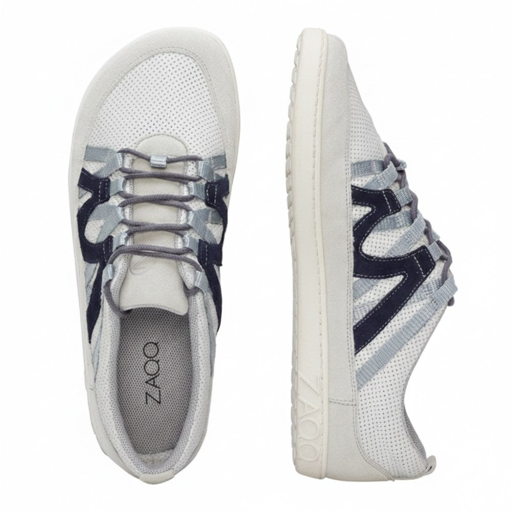 Die ZAQQ DRAQE Sneaker in Weiß und Grau mit marineblauen Akzenten sind aus hochwertigem Nappaleder gefertigt und haben perforierte Oberteile. Das Schnürdesign wird durch das Branding an der Seite und der Innensohle aufgewertet und bietet eine Draufsicht, die sowohl die Seite als auch die Sohle hervorhebt.