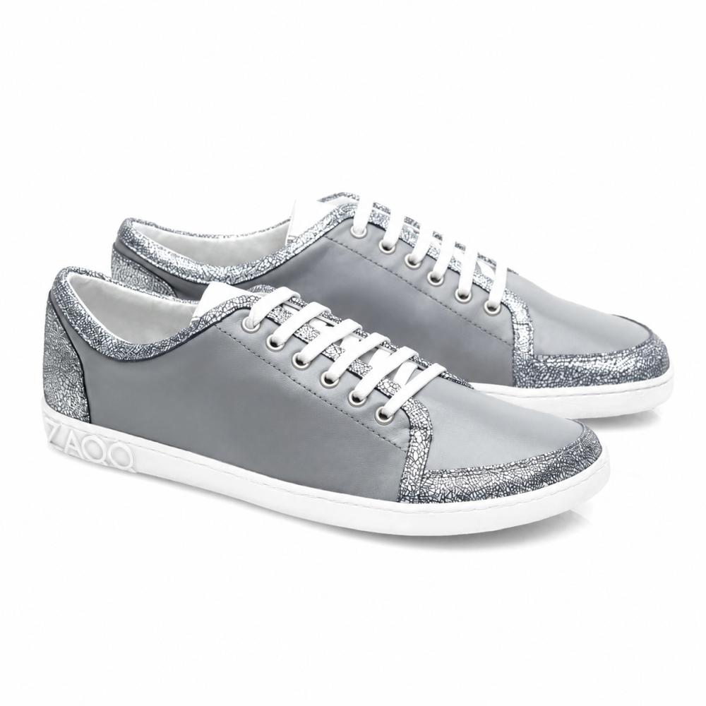TIQQ Grey Silver -lenkkarit ZAQQ: Yksinkertainen muotoilu pehmeästä nappanahasta valkoisilla nauhoilla ja hopeisilla kimalteilla, valkoiset pohjat ja hienovarainen logo kannassa tarjoavat täydellisen yhdistelmän tyyliä ja mukavuutta joka tilanteeseen.